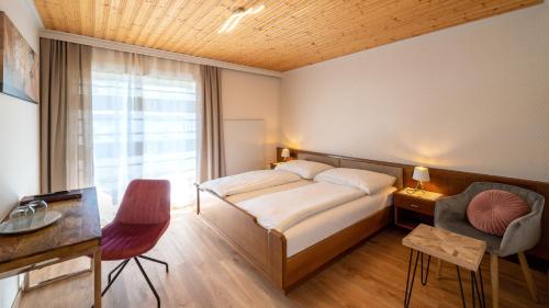 a hotel room with a bed and a desk and a window at Frühstückspension Slanitsch in Sankt Kanzian