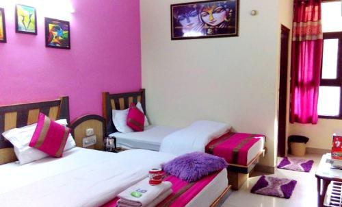 2 camas en una habitación con paredes rosas en Hotel Majors Den, en Nueva Delhi