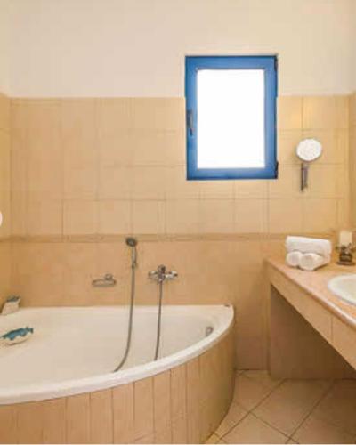 a bathroom with a bath tub and a sink at Villa Poseidon Blue in Rhodes Town