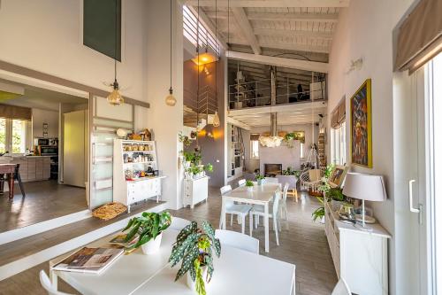 a living room with white tables and chairs at Il Sassoscritto Bed and Breakfast in Montecalvo Versiggia