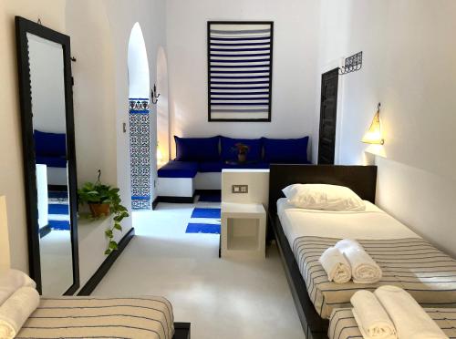 um quarto com 2 camas e um sofá em Dar Hannan em Chefchaouene