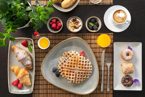 a table with a plate of waffles and other breakfast foods at Duparc Hotel in Gabicce Mare