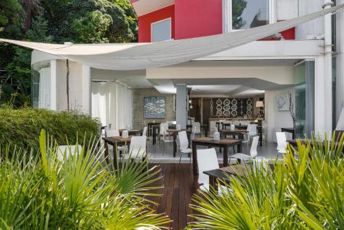 ein Restaurant mit Tischen und Stühlen unter einer weißen Markise in der Unterkunft Duparc Hotel in Gabicce Mare