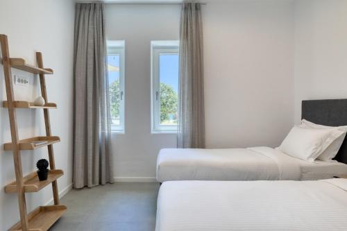 a hotel room with two beds and a window at Elia Mykonos Resort in Elia Beach