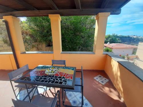 un patio con tavolo e sedie sul balcone. di Casa Raia - Overlooking the sea a Procida