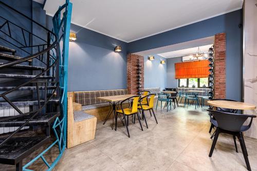 a dining room with tables and chairs and blue walls at Kope Palace in Tbilisi City