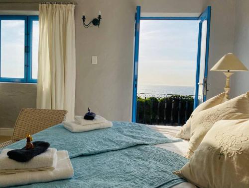 a bedroom with a large bed with a view of the ocean at Casa Balena - Gansbaai seafront accommodation, back-up power in Gansbaai