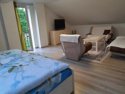 a bedroom with a bed and a couch and a chair at Privat Magnolia in Mošovce