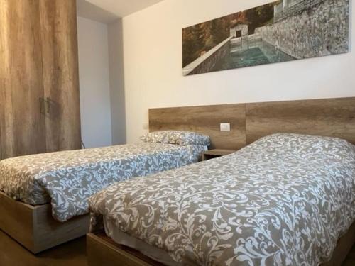 1 dormitorio con 2 camas y una foto en la pared en Appartamento trilocale luxory,sulle piste da sci en Bormio