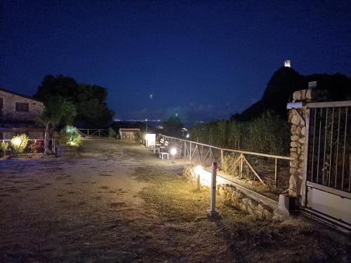 a farm at night with a fence and a field at Casolare La Torre in Scopello