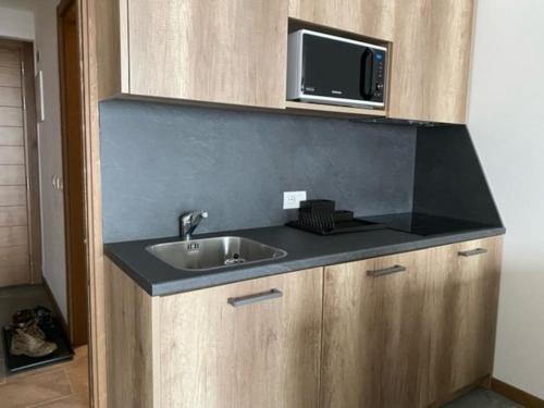 a kitchen with a sink and a microwave at Appartamento trilocale luxory,sulle piste da sci in Bormio