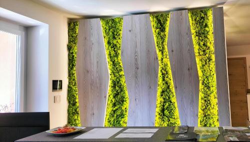 a room with a wall covered in green ivy at Agritur La Fenice in Brez