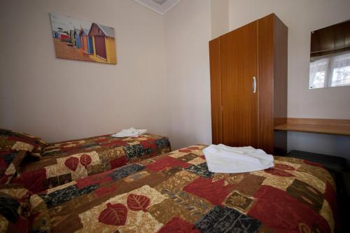 a hotel room with a bed and a cabinet at Manjimup Motor Inn in Manjimup