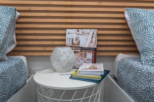 a room with two beds and a table with books at VeraLuce in Caltavuturo