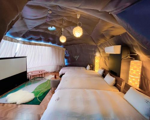 een kamer met een groot bed in een tent bij Necoana Glamping in Fujikawaguchiko