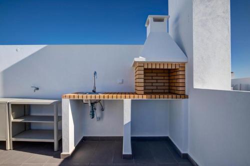 a kitchen with a counter with a stove at Luxury Two Bedroom Apartment with Private Roof Terrace and Hot Tub in Alvor