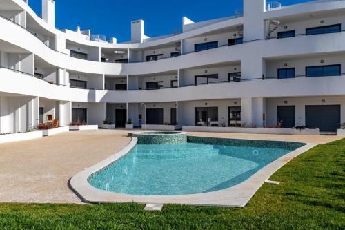 an external view of a building with a swimming pool at Luxury Two Bedroom Apartment with Private Roof Terrace and Hot Tub in Alvor