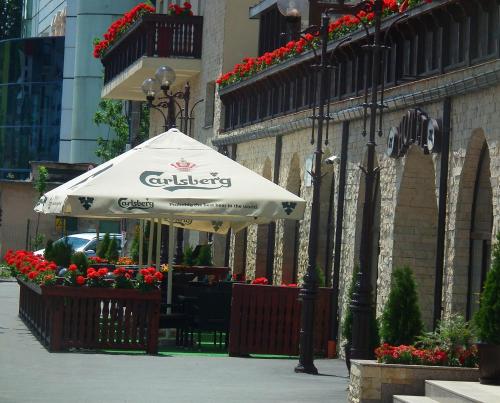um guarda-chuva branco num passeio ao lado de um edifício em Hotel Carmen em Predeal