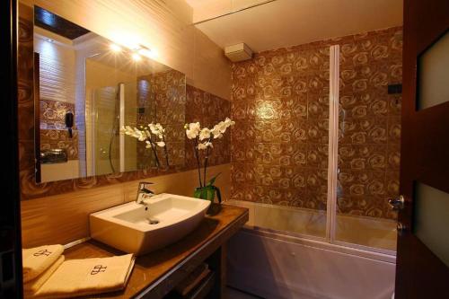 a bathroom with a sink and a shower and a tub at Hotel Partner in Vlorë