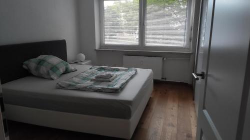 ein kleines Schlafzimmer mit einem Bett und einem Fenster in der Unterkunft Brilliant Home Messe in Nürnberg