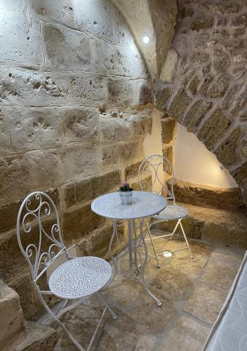 a table and two chairs in a stone room at Agrimi b&b in Mesagne