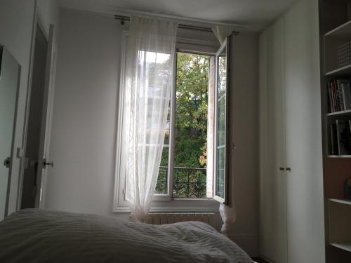 une chambre avec un lit et une fenêtre dans l'établissement Alex Flats, à Paris