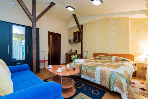 a bedroom with a bed and a blue couch at Po Jūros Banga in Palanga