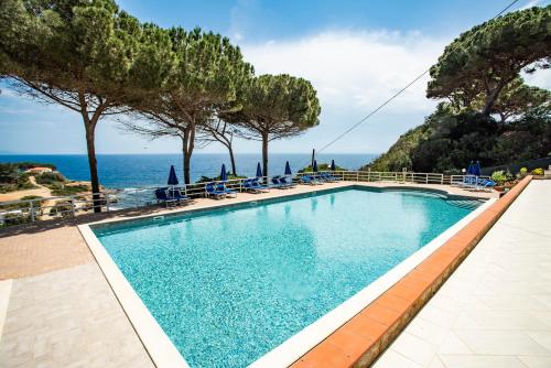 a swimming pool with a view of the ocean at Residence Reale in Porto Azzurro