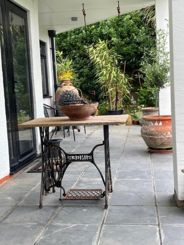 a table with a vase on it on a patio at Cliff top Garden room in Milford on Sea