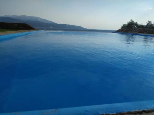 a large pool of blue water with mountains in the background at PRINCESS OF BLUE EAGLES RETREAT in Skaloma