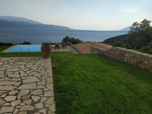a view of a yard with a stone wall and a pool at PRINCESS OF BLUE EAGLES RETREAT in Skaloma