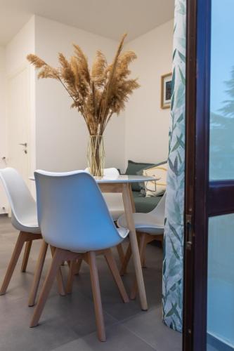 a table with chairs and a vase with a plant at VeraLuce in Caltavuturo