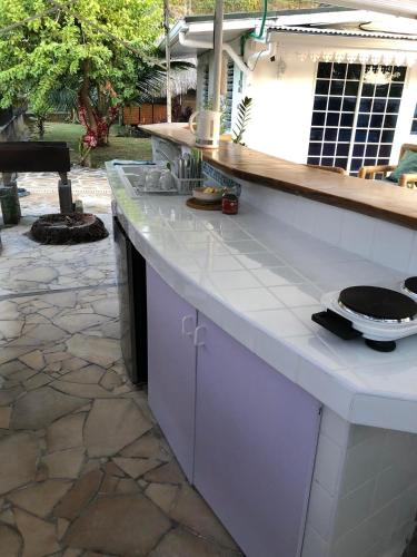 a kitchen with a white counter and a stone patio at FARE TEMANEA in Papetoai