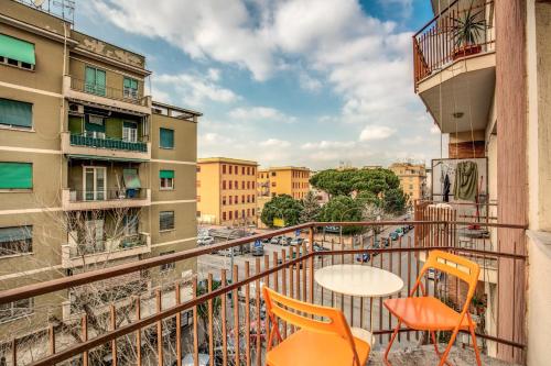 a balcony with orange chairs and a table and buildings at City Guest House in Rome
