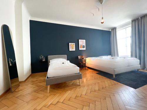 a bedroom with two beds and a blue wall at Stadtjuwel mit Pfänderblick in Bregenz