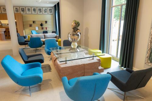 a living room with blue chairs and a glass table at DEINHARD's in Bernkastel-Kues