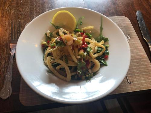 a white bowl of food with pasta and a lemon at The Griffin Llyswen in Brecon
