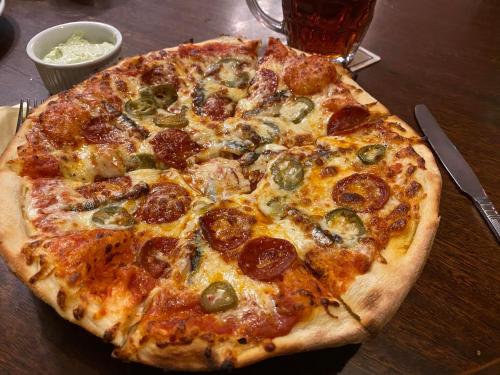 a pizza sitting on top of a wooden table at The Griffin Llyswen in Brecon