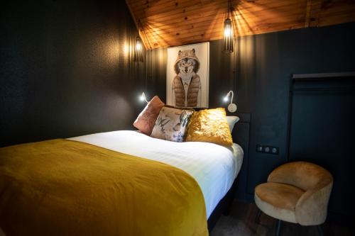 a bedroom with a bed and a chair at ISKÖ CHALETS-HÖTEL, Col d'Aubisque in Gourette