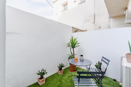 un patio avec une table, des chaises et des plantes dans l'établissement Le CapCanaille par Dodo-a-Cassis, à Cassis