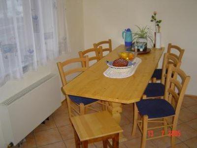 un tavolo e sedie in legno con un cesto di frutta. di Apartmaji Sparakel a Bled