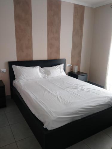 1 cama grande con sábanas y almohadas blancas en Appartamento Eleonora, en Muscoline