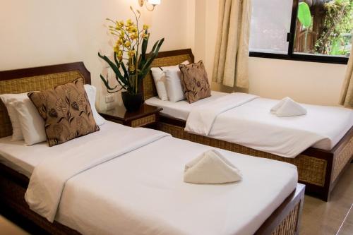 two beds in a room with white sheets and pillows at Marick Beach Resort in Carmen
