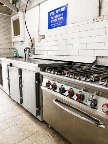 a kitchen with a stove top in a kitchen at Etzel Tami Hospitality in Neot Golan