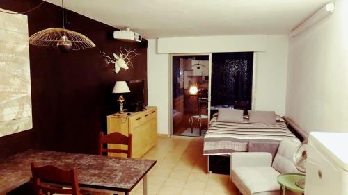 Una sala de estar con una cama y un comedor. en Studio à Calvi proche de la mer et des commerces, en Calvi