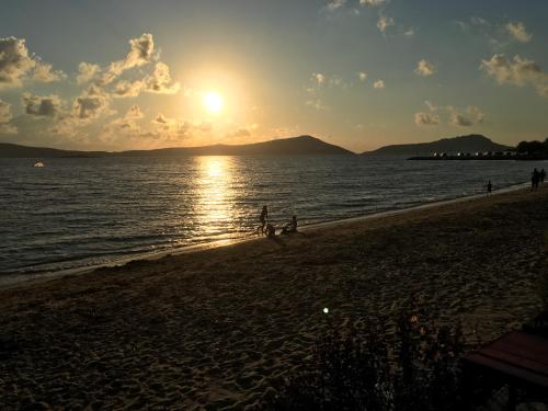 two people walking on the beach at sunset at Gialova garden bungalow in Gialova