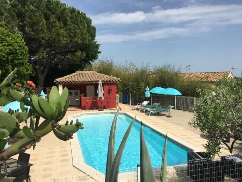 - une piscine dans une cour avec un kiosque dans l'établissement Gites Còr Causy OLEANDER, à Causses-et-Veyran