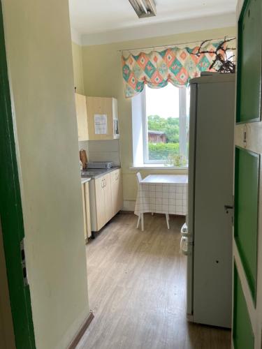 a kitchen with a refrigerator, sink and a window at Endla Hostel in Haapsalu