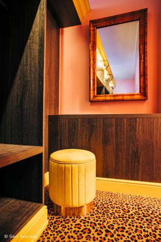 a circular stool in a room with a mirror at Flora in Antwerp