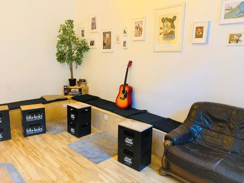 a living room with a couch and a guitar on the wall at Jimmy Jumps House in Vilnius